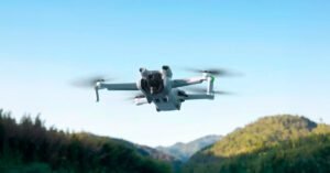 Um drone DJI Mini 3 voando imponente sobre montanhas.