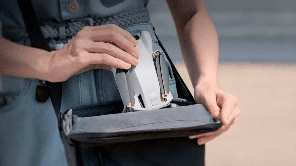 Usuário tirando o drone DJI Mini 3 da bolsa para poder voar.