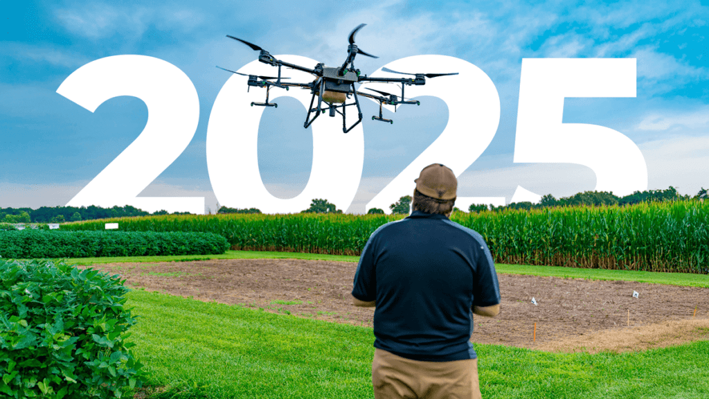 Um piloto de drone agrícola pilotando seu drone e olhando pro horizonte.