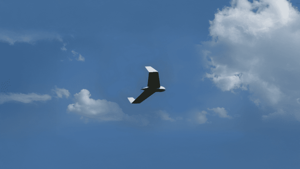 Drone Carcará em voo sob o céu azul, representando o avanço do drone militar brasileiro e a busca pela soberania tecnológica.